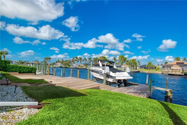 dock area with a water view and a yard