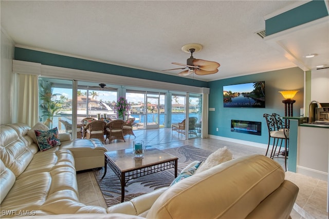 living room featuring ornamental molding, a textured ceiling, and ceiling fan