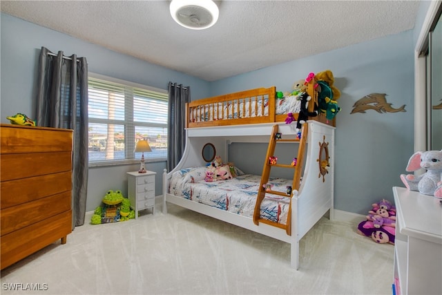 bedroom with a textured ceiling and light carpet