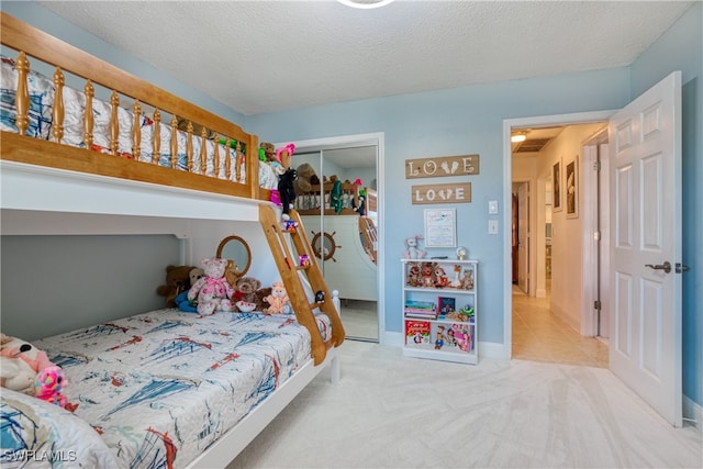 bedroom featuring light carpet, a closet, and a textured ceiling