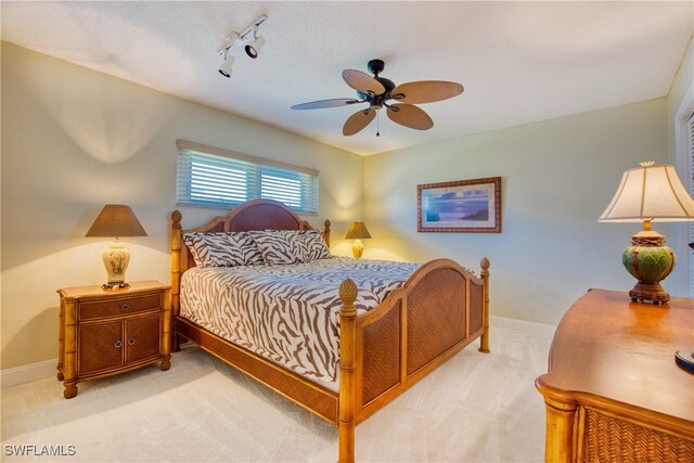 carpeted bedroom with ceiling fan and track lighting