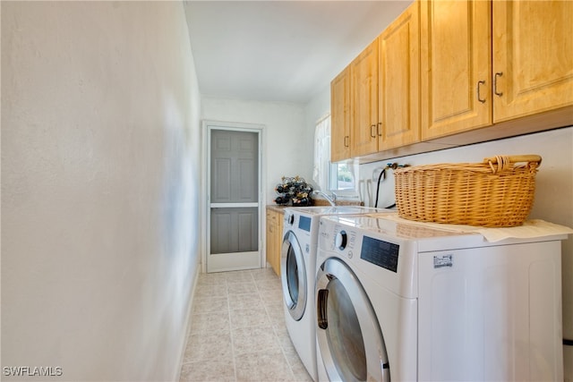 clothes washing area featuring cabinets and washing machine and clothes dryer