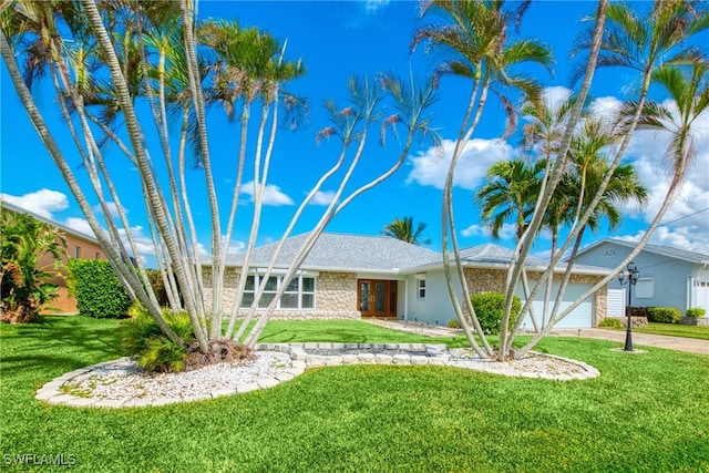 ranch-style house featuring a garage and a front lawn