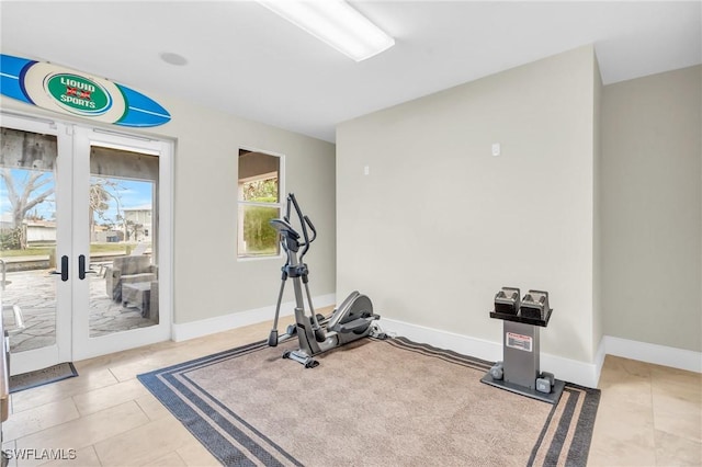 exercise room with baseboards and tile patterned floors