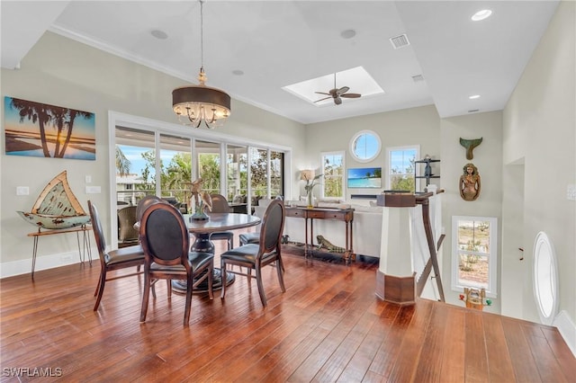 dining area with dark wood-type flooring, a skylight, a healthy amount of sunlight, and visible vents