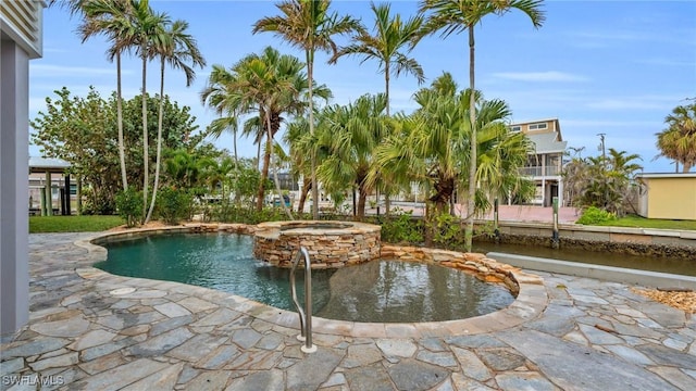 view of swimming pool featuring a pool with connected hot tub and a patio area