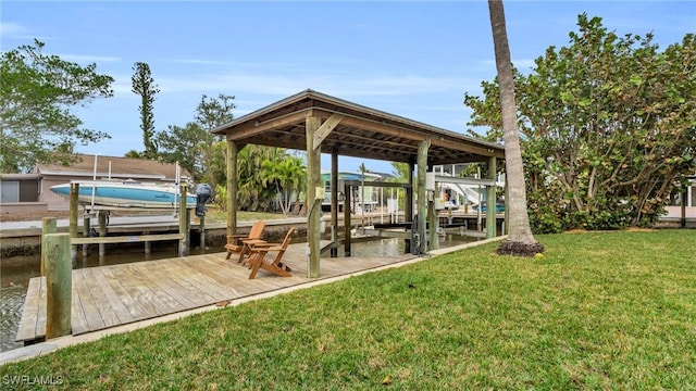 dock area with a water view, boat lift, and a yard