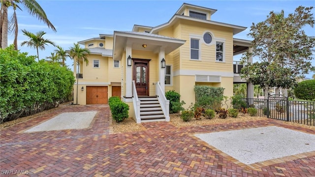 view of front of property with a garage, decorative driveway, and fence