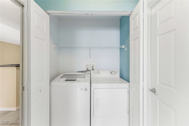 clothes washing area featuring washing machine and clothes dryer and light tile patterned floors