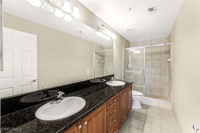 bathroom featuring vanity, walk in shower, tile patterned flooring, and toilet