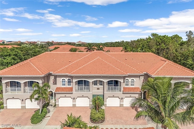 mediterranean / spanish house featuring a garage and a balcony