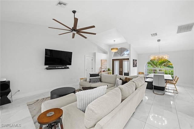 living room with ceiling fan with notable chandelier, french doors, and vaulted ceiling