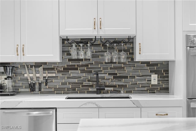 kitchen with white cabinetry, light stone countertops, and dishwasher