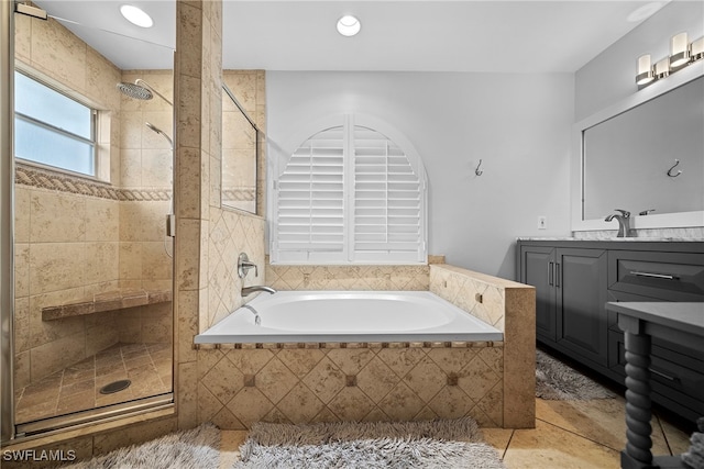 bathroom with tile patterned floors, vanity, and shower with separate bathtub