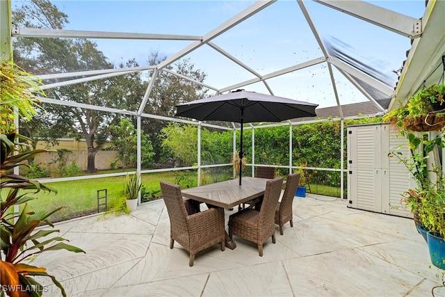 view of patio with a shed and glass enclosure