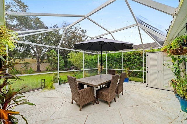 view of patio featuring a lanai and a storage shed