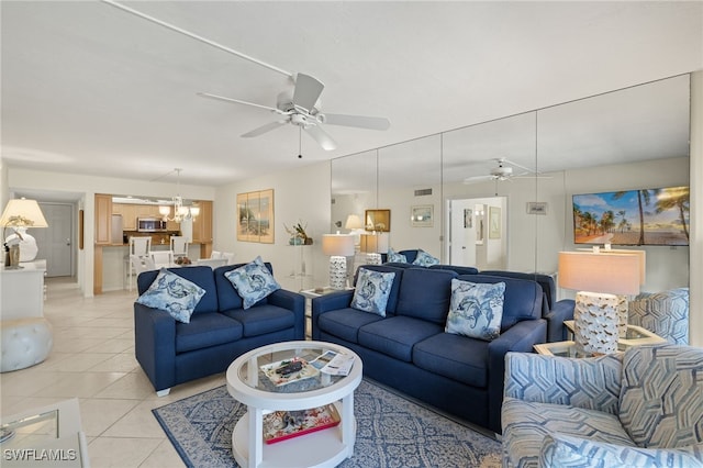 living room with light tile patterned flooring and ceiling fan with notable chandelier