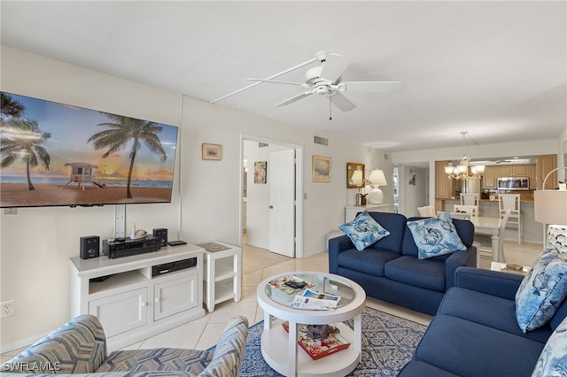 tiled living room featuring ceiling fan with notable chandelier