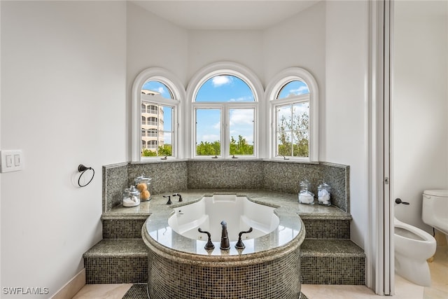 bathroom with a relaxing tiled tub, a bidet, tile patterned floors, and toilet