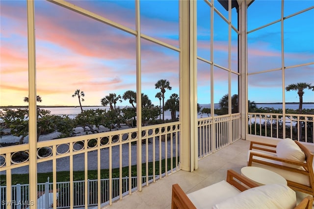 sunroom / solarium featuring a water view