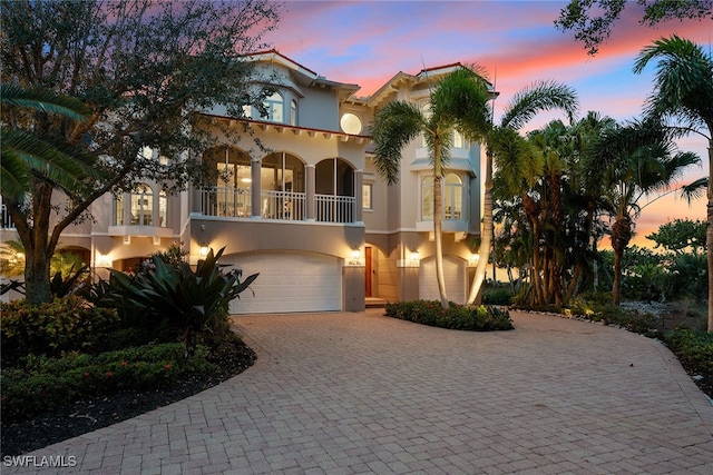 mediterranean / spanish house featuring a garage and a balcony