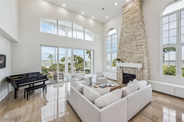 living room featuring a high ceiling, a wealth of natural light, and a fireplace