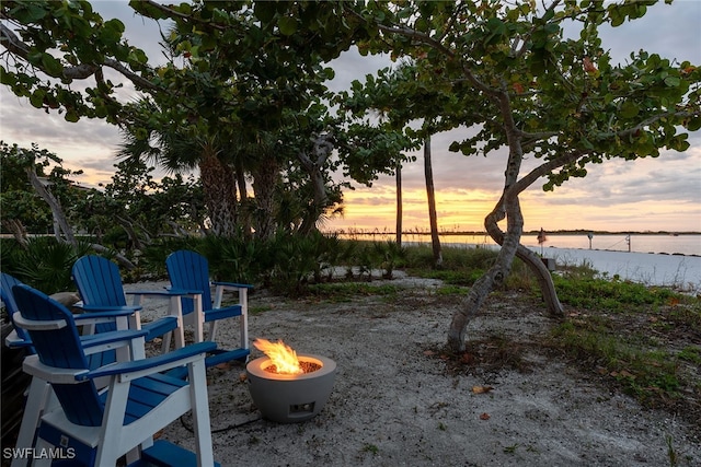 yard at dusk featuring a water view