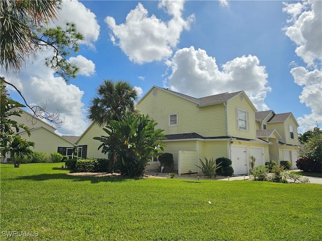 view of home's exterior with a garage, a lawn, and driveway