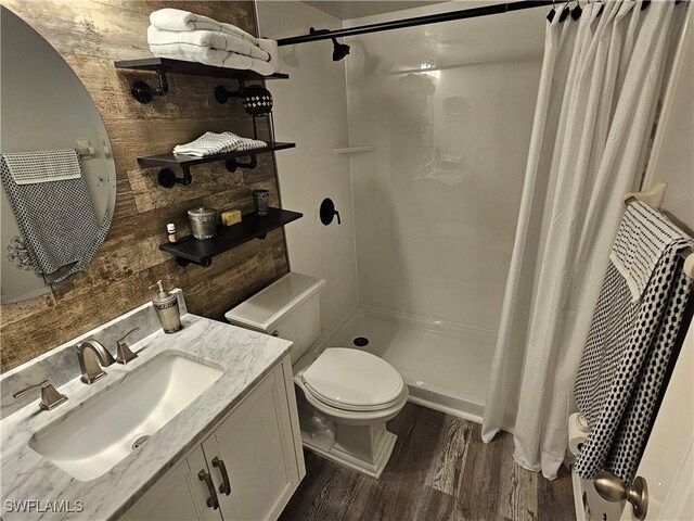 bathroom featuring hardwood / wood-style floors, a shower with shower curtain, toilet, and vanity