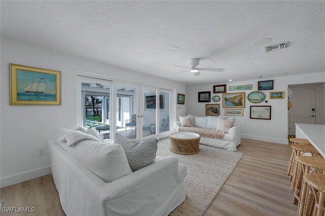 living room with french doors, ceiling fan, and light hardwood / wood-style flooring