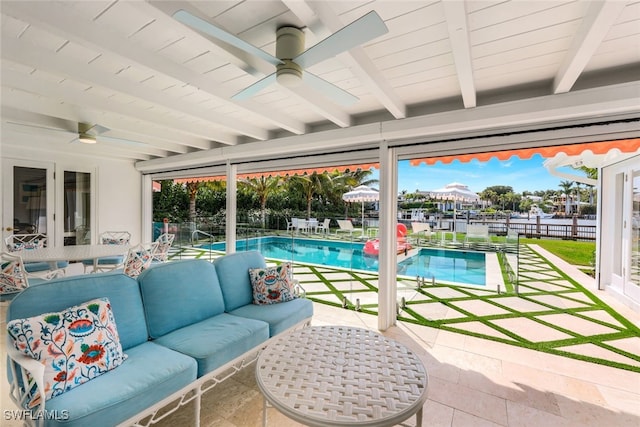 exterior space with beam ceiling, plenty of natural light, and a pool