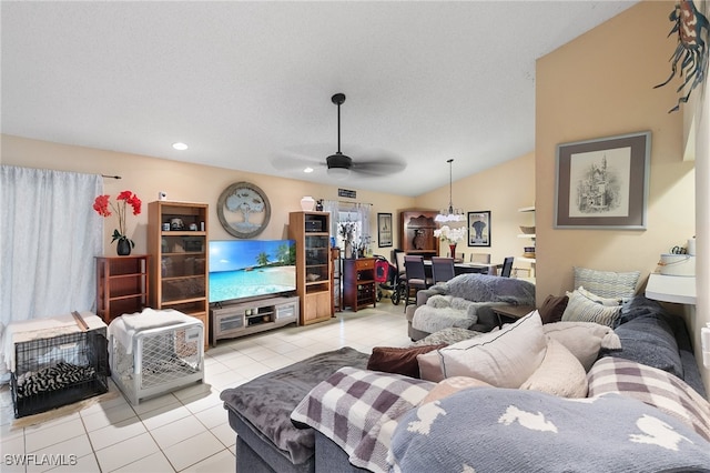 living room featuring a textured ceiling, vaulted ceiling, light tile patterned floors, and ceiling fan with notable chandelier