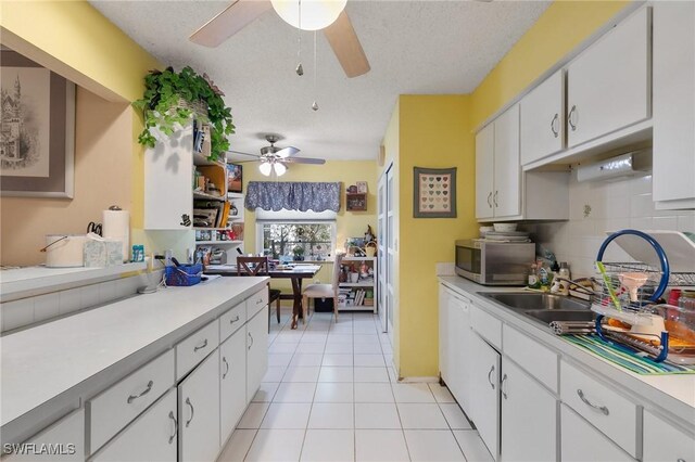 120 Sand Hill St, Marco Island, FL 34145 - kitchen featuring stainless steel microwave, a ceiling fan, light countertops, white cabinetry, and a textured ceiling
