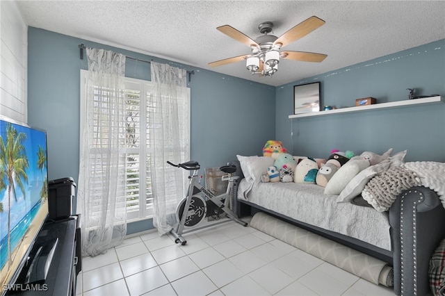 tiled bedroom with a textured ceiling and ceiling fan