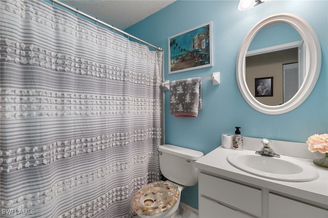 bathroom with vanity, a textured ceiling, and toilet