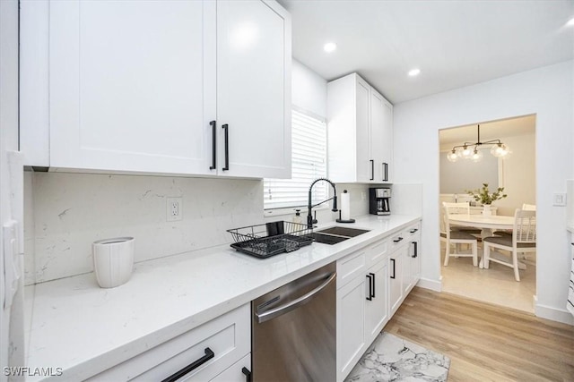 kitchen with light hardwood / wood-style flooring, light stone countertops, stainless steel dishwasher, sink, and white cabinetry