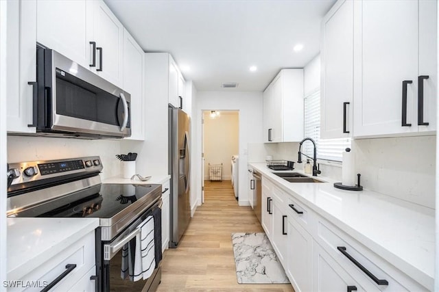 4126 Belair Ln Unit C6, Naples, FL 34103 - kitchen with appliances with stainless steel finishes, a sink, light wood-type flooring, white cabinets, and recessed lighting