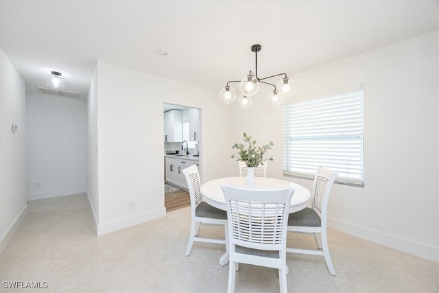 tiled dining room with a notable chandelier and sink