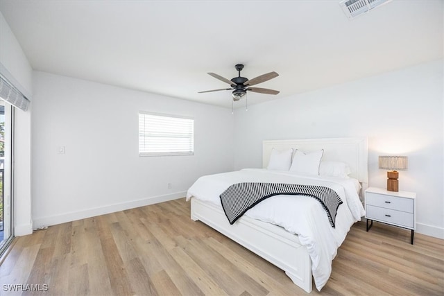 bedroom with multiple windows, ceiling fan, and light hardwood / wood-style floors