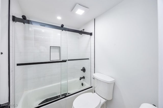 bathroom with shower / bath combination with glass door and toilet