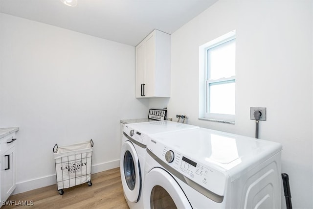 washroom with light hardwood / wood-style flooring, washer and clothes dryer, and cabinets