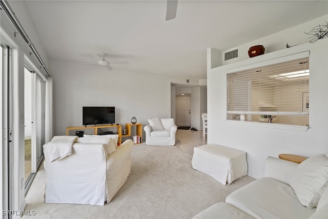 carpeted living room with ceiling fan