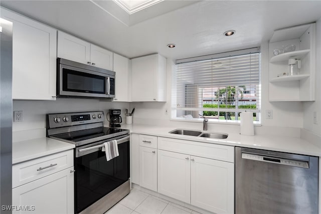 kitchen with light tile patterned floors, white cabinetry, sink, and appliances with stainless steel finishes