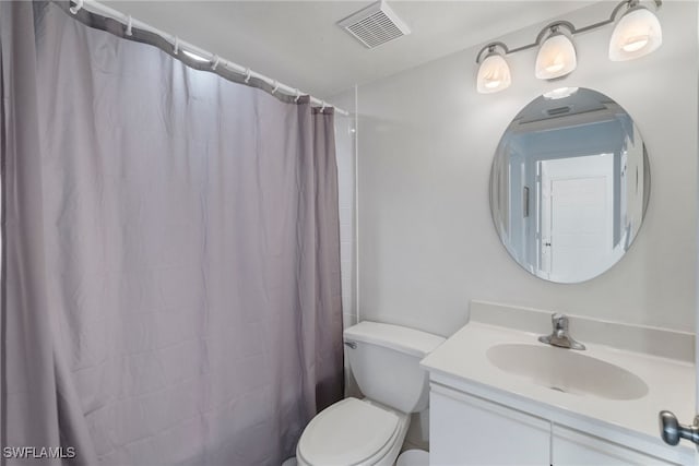 bathroom featuring toilet, vanity, and walk in shower