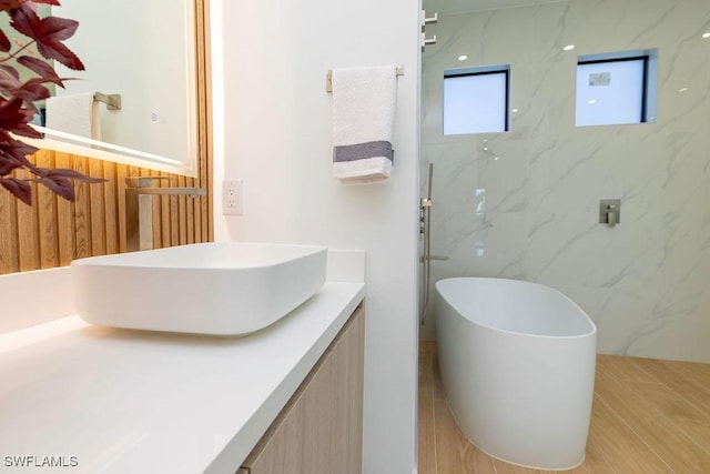 bathroom with vanity and a bath