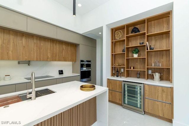 kitchen featuring double oven, wine cooler, sink, and black electric cooktop