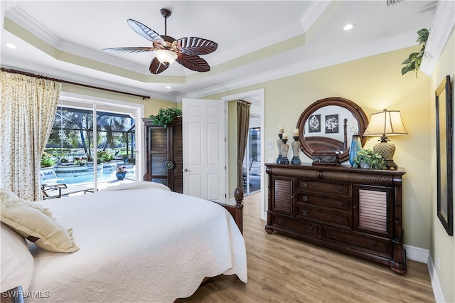 bedroom featuring light hardwood / wood-style floors, ceiling fan, access to exterior, a raised ceiling, and crown molding