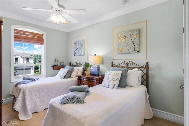 carpeted bedroom featuring ornamental molding and ceiling fan