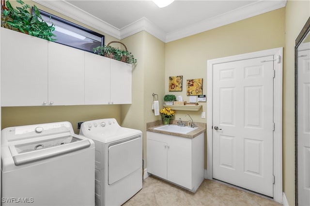 clothes washing area with washer and clothes dryer, cabinets, sink, and ornamental molding