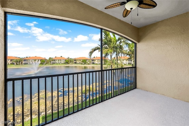 unfurnished sunroom featuring a water view and ceiling fan